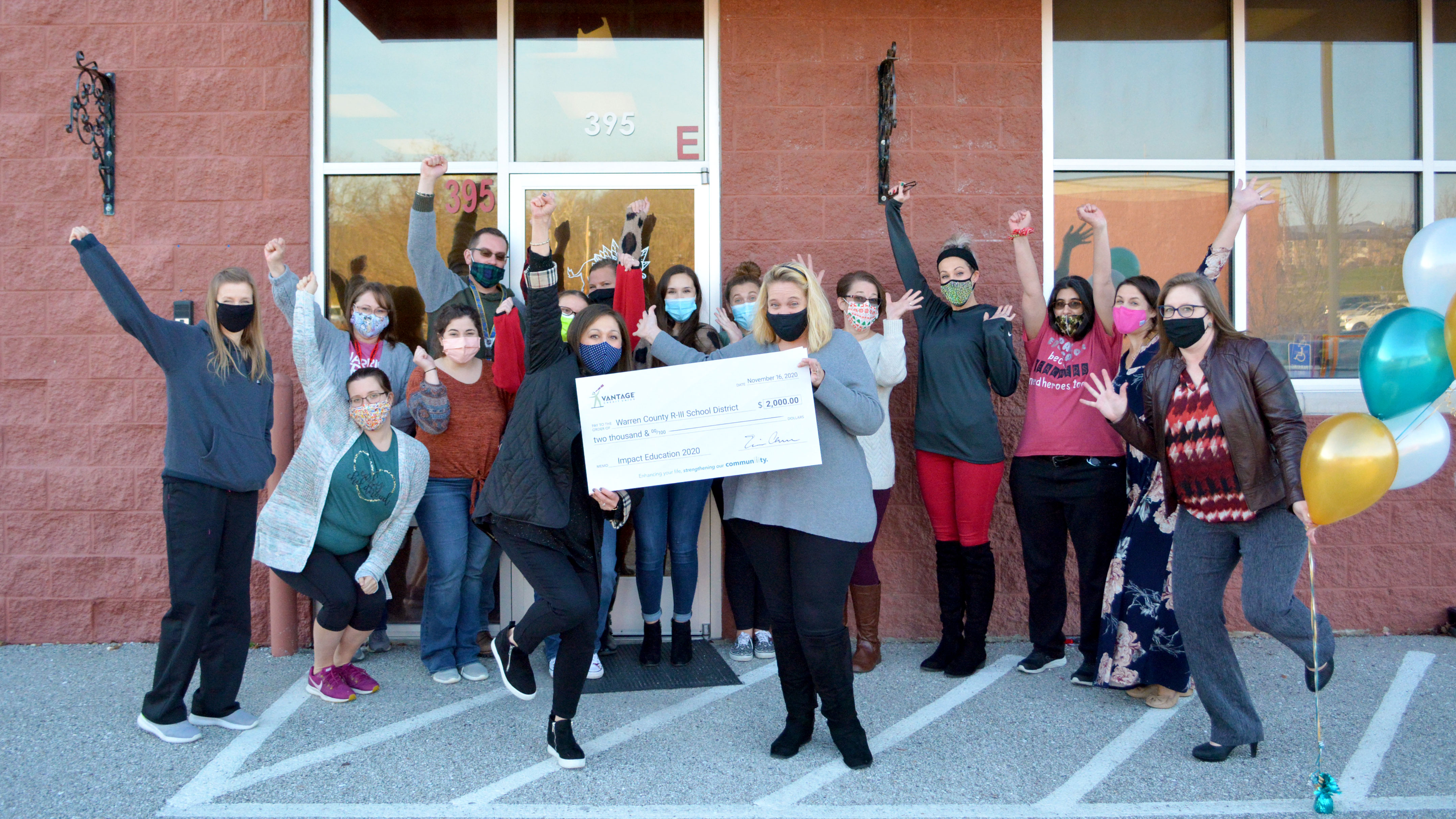 2020-news-robin-olive Teachers holding a large check