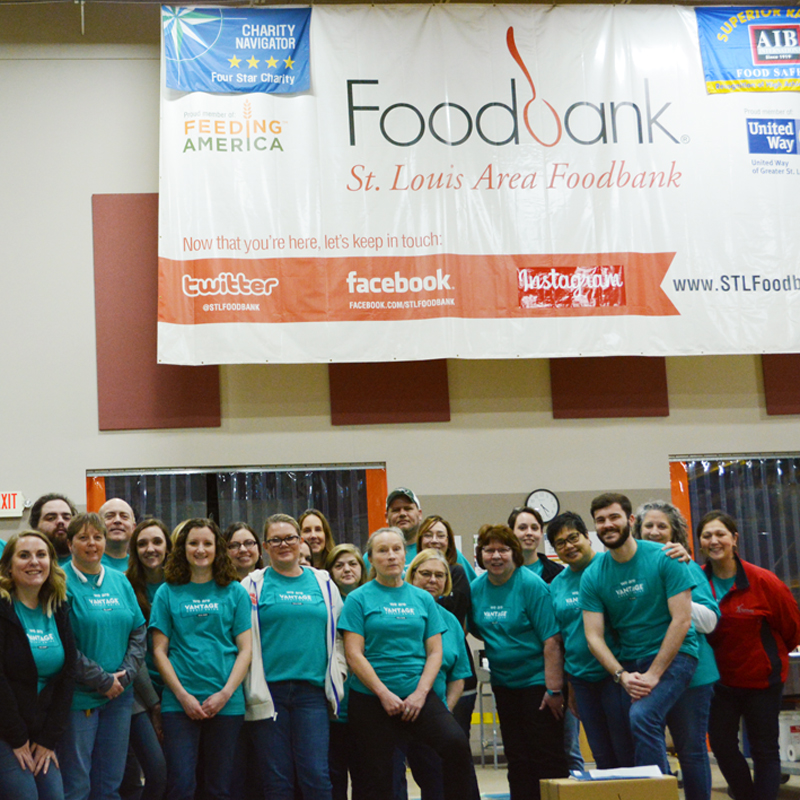 Volunteers posing for a picture while working at a food bank