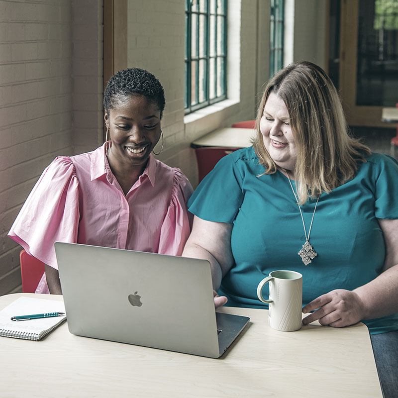 Two people looking at a laptop