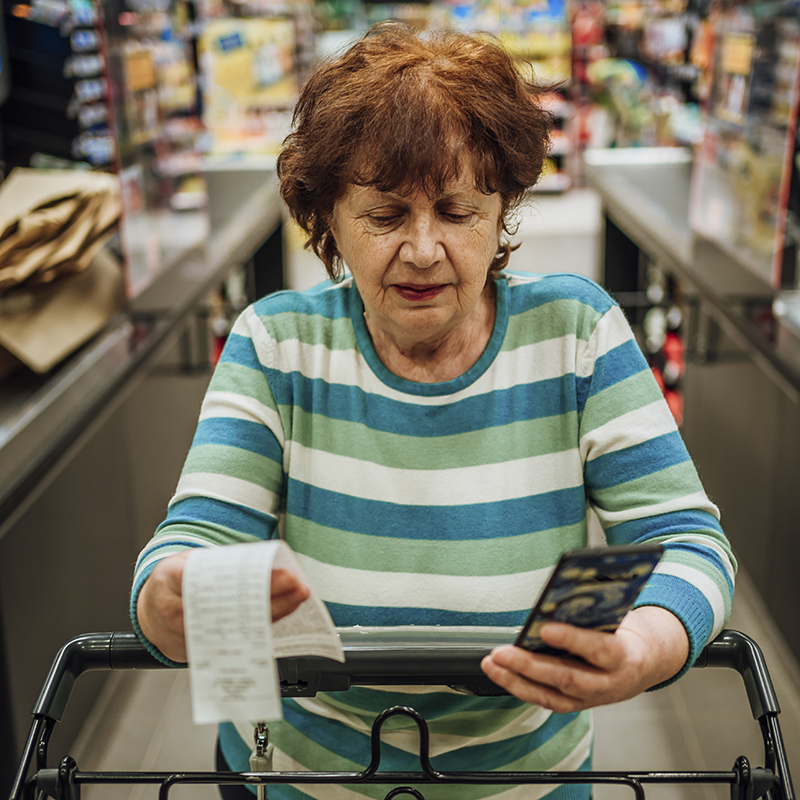 An elderly woman grocery shopping