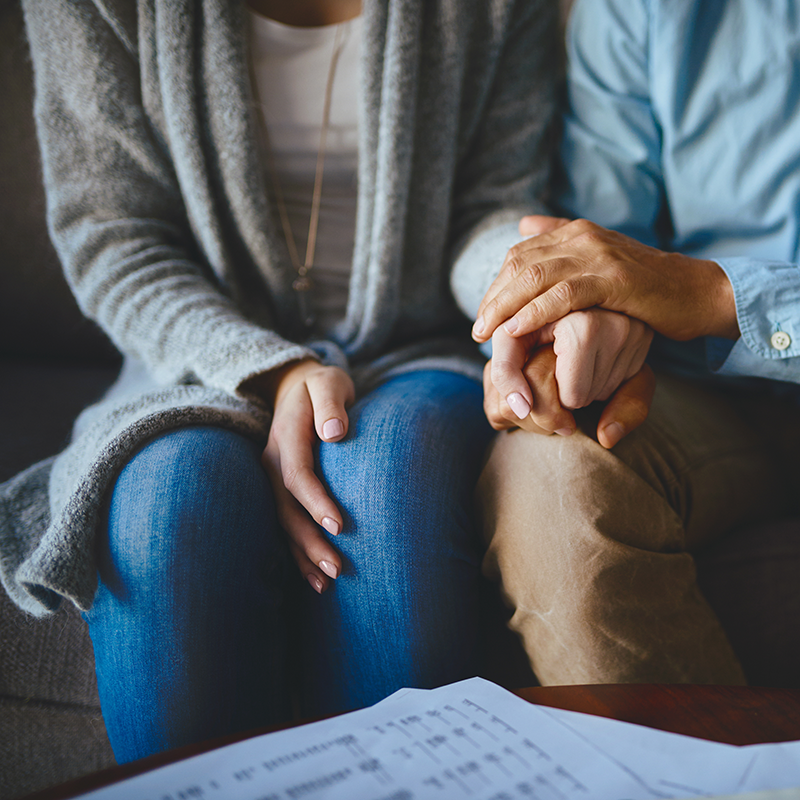 A close up of a couple holding hands