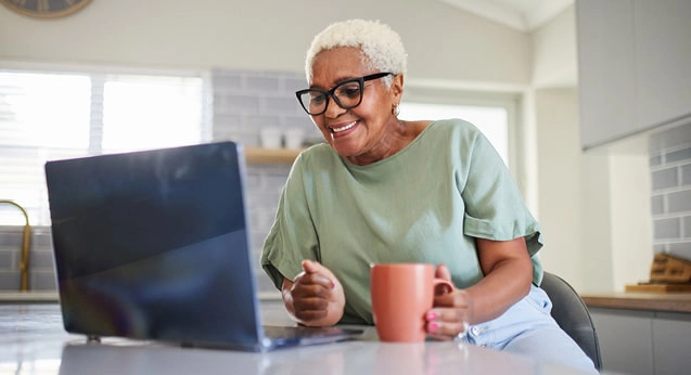 A woman drinking coffee on her laptop